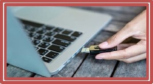 A person plugging a USB into a computer.