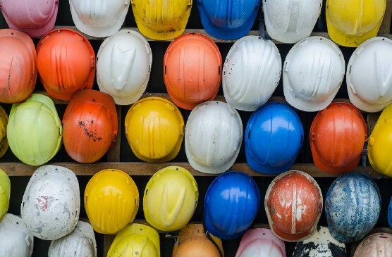 Rows of colorful construction hard hats.