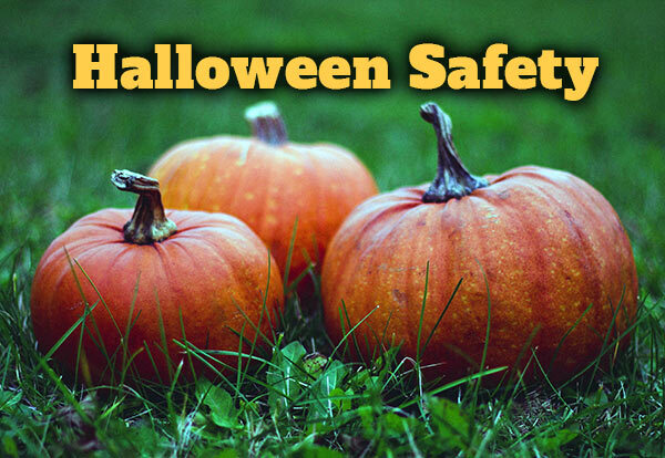 Halloween Safety. Three pumpkins in a field of grass.